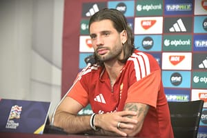 2026 0924 magyar labdarúgó-válogatott edzés fotó-szokodi lászló - szokodi academy media 4 - szokodi academy media Man in a red sports jersey sits at a press conference table, microphone in front, backdrop with sponsor logos behind him